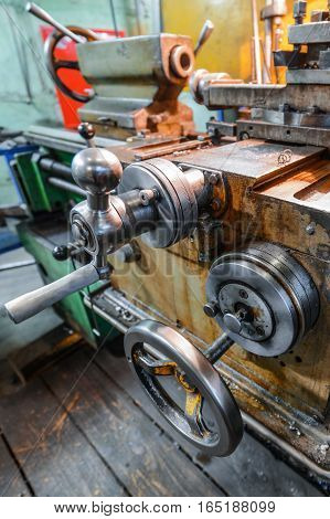 The carriage slide. Mechanical wheel carriage control. Vintage metal cutting lathe. The old mechanical cutting equipment.