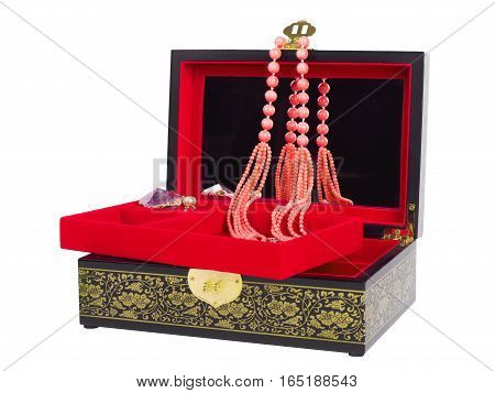 Picture of the opened jewel-box with red fit-out. Wooden jewel-box with pink coral bead necklace isolated on white background. Side view.