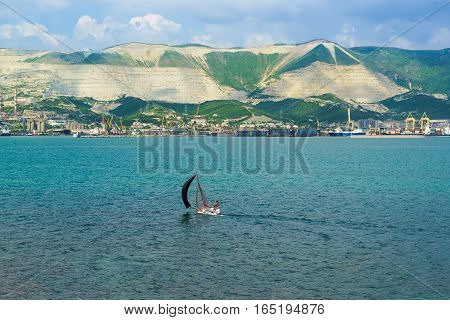 Sports sailboat and panorama of Novorossiysk commercial sea port