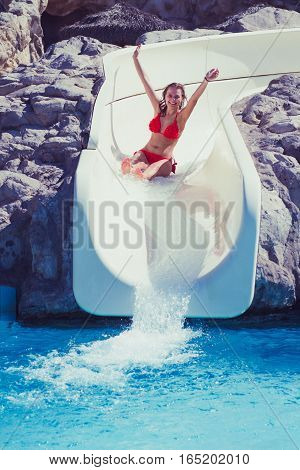 Blond Girl Riding Slide In Waterpark