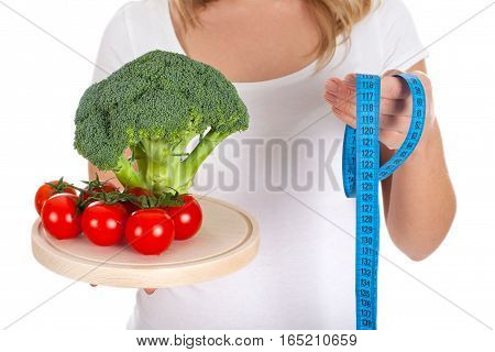 Picture of fresh vegetables and measurer held by a woman