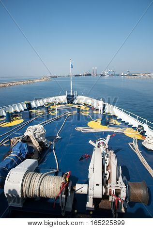 Foredeck of a cruise ship sailing in the ocean and arriving in the harbor.