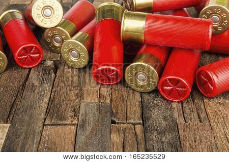 12 gauge red hunting cartridges for shotgun on wooden background. Macro shot.