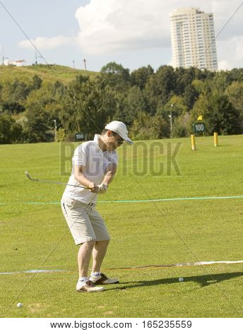 MOSCOW - AUGUST 17 2013: man plays golf on golf-fields in sport complex Krylatskoye in region Krylatskiye hills.
