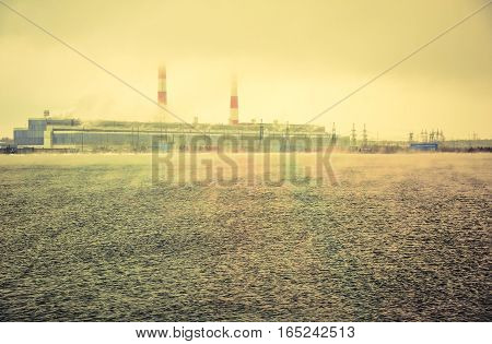 Gas power plant. Pipes with smoke. Lake with fog foreground. Energy industry concept. Toned.