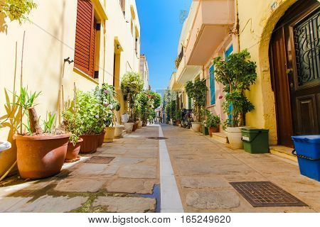 Rethymnon Island Crete Greece - June 23 2016: The narrow street of Rethymnon (part of Old Town) where there are a lot of pots with flowers