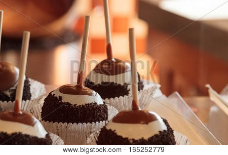 Candy apples with caramel and nuts on a stick in a candy store window