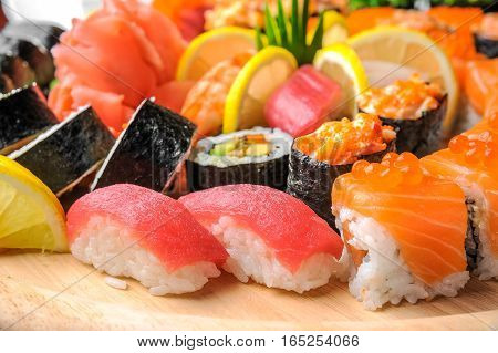 Nigiri sushi and sushi rolls with fish served on wooden table