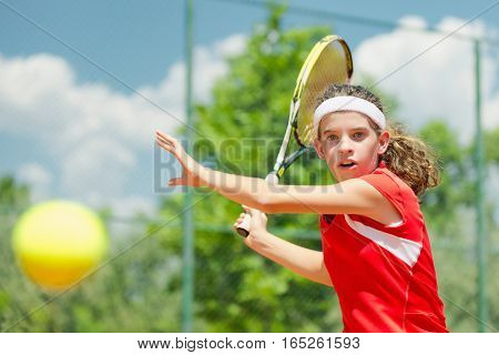 Young tennis champion hitting forehand, toned image