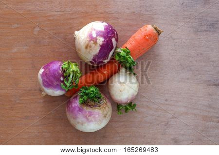 picture of a carot and radishes on a woodbackground