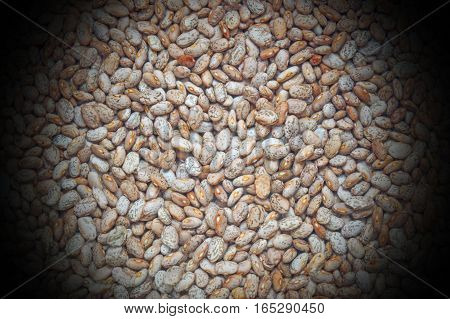 Uncooked pinto beans texture with black background.