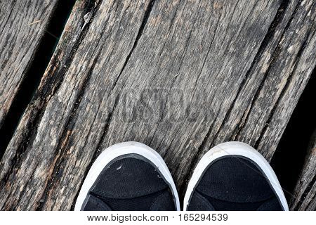 Black and white Shoes stand on old wooden pier floor. Wood pier abstract texture of a natural gray. View of old weathered deck wooden board. Diagonal wood background texture.