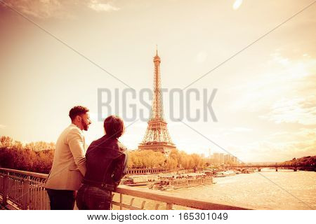 Multi-ethnic couple enjoying their trip to Paris along the Seine river, near Eiffel Tower.