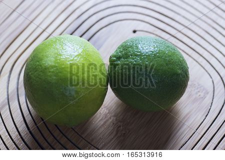 fresh green lemon on wooden background, closeup
