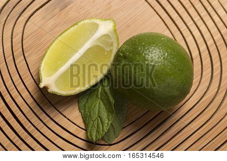 fresh green lemon and spearmint on wooden background