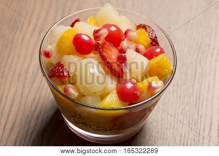 fruit salad in glass bowl with wooden background