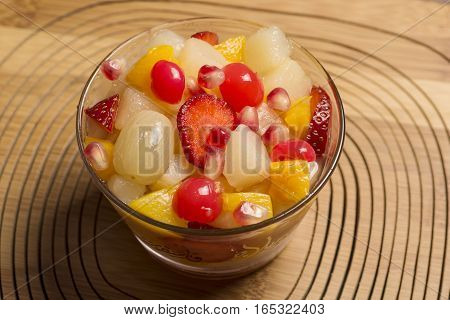 fruit salad in glass bowl with wooden background