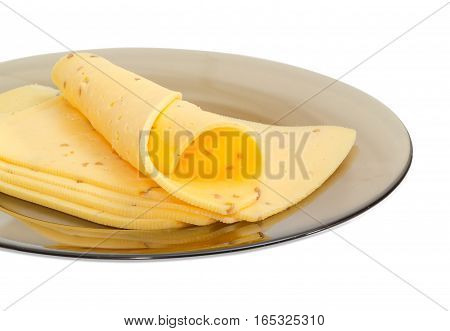 Fragment of glass dish with several slices of a semi-hard cheese made with pounded walnuts closeup on a light background