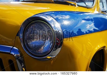MOSCOW RUSSIA - OCTOBER 1 2016: Headlamp of an old legendary Soviet car Volga GAZ M-21. Police car coloring.