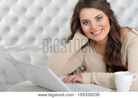 Portrait of woman using laptop in light room