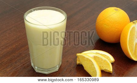 Healthy Orange Fruit Smoothie In A Stemless Glass On Wooden Background With Fresh Oranges Slices