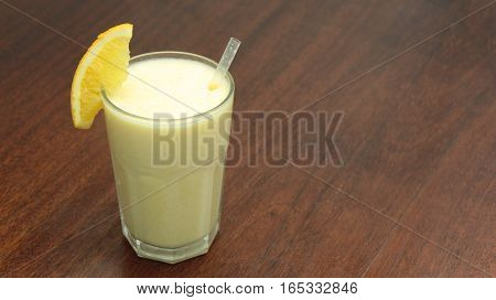 Healthy Orange Fruit Smoothie In A Stemless Glass On Wooden Background With Fresh Oranges Slices