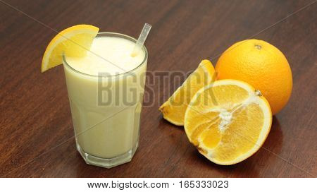 Healthy Orange Fruit Smoothie In A Stemless Glass On Wooden Background With Fresh Oranges Slices