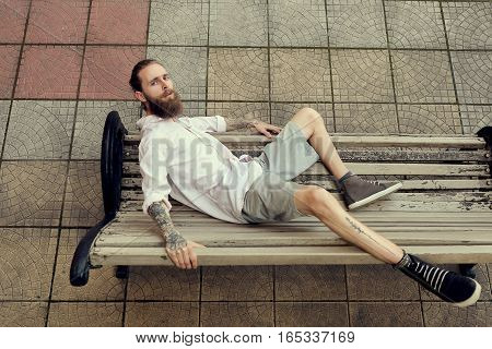 Bearded Tattooed Lying On Chair And Posing In Fashion Style