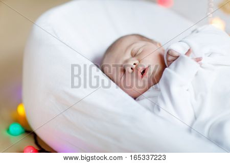 Cute adorable newborn baby sleeping in white bed. New born child, little girl laying in bed. Family, new life, childhood, beginning concept.