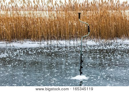 A boer makes a hole in the ice