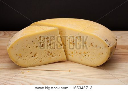 Sliced piece of cheese on a wooden table