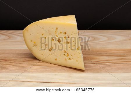 Sliced piece of cheese on a wooden table
