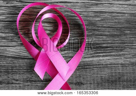 health symbol pink ribbon on wooden board background.