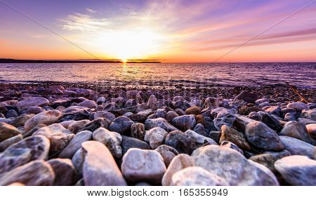 Stones On A Beach With Sunset On The Ocean Sea.