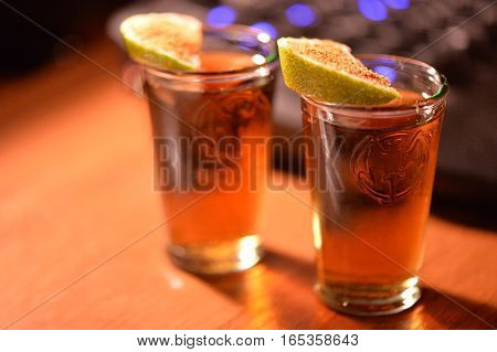 Two stacks of rum with lime and cinnamon on the table
