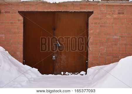 A BRICK GARAGE BUILT OF RED BRICK GATE METAL