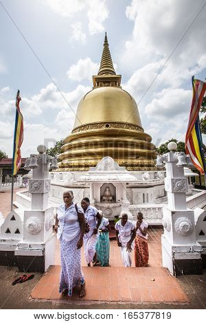 DAMBULLA, SRI LANKA. July 22, 2016: Women in traditional Sri Lankan dress in Dambulla near the Golden Temple Peace Pagoda Stupa.