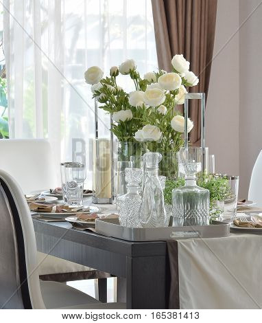dining wooden table and comfortable chairs in modern home with elegant table setting