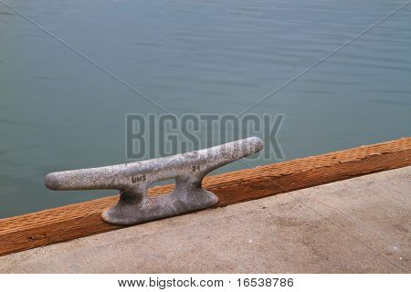 Steek Dock spiken på træ bjælke ved siden af beton med en backbround af vand