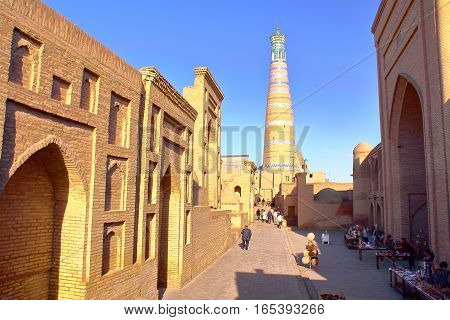 KHIVA, UZBEKISTAN - MAY 6, 2011: An alley inside Khiva old town with The Islam Khodja minaret in the background