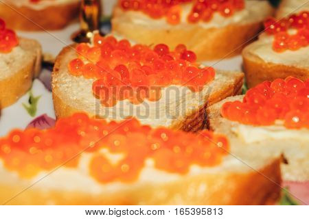 Red caviar on bread with butter close-up lots of sandwiches