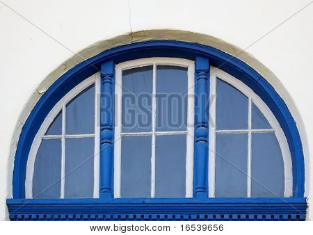 Azul incomum aparado frame de janela do arco no edifício de estuque
