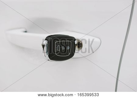 Car keys in white door lock closeup with copy space. Opening car door with key