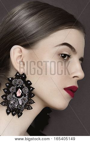 Portrait of young beauty dark hair girl in vintage style dress with beautiful hair and big earrings
