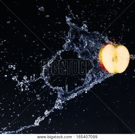 the half apple in water, on black nackground