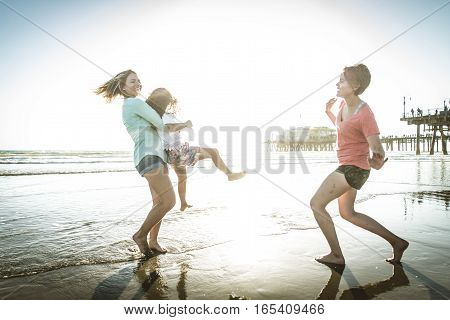 Lesbians mothers with adopted child - Happy homosexual family playing with her daughter