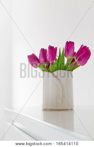 Beautiful Fresh Spring lila Tulips in Vase on bright background. Spring easter or Mother's Day Concept.