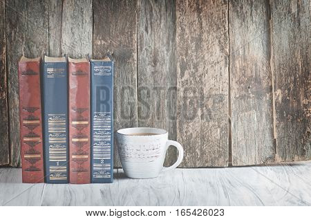 a pile of old books on a wooden retro background and a white worktop