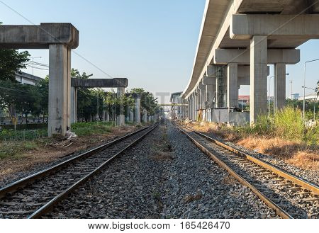 Two railway train under concrete construction blue sky background