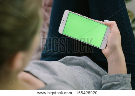 Beautiful girl holding a smartphone in the hands of a green screen green screen, hand of man holding mobile smart phone with chroma key green screen on white background, new technology concept